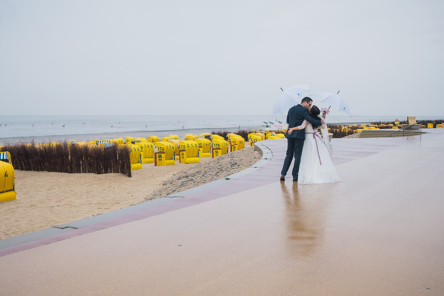 Hochzeitsfotos Sahlenburg mit Brautpaar und Regenschirmen